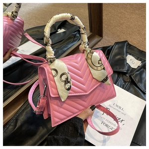 Detail of pink quilted shoulder bag with V-shaped stitching and floral scarf handle wrap