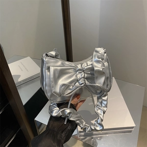 Metallic silver underarm bag with large bow detail and ruffled handle in Y2K style