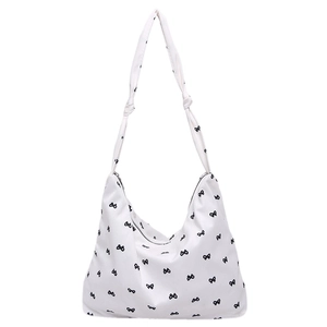 White floral canvas hobo tote bag with black bow print and knotted shoulder strap detail