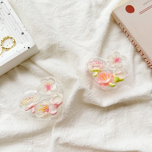 Detail of glitter heart phone grips featuring embedded cherry blossoms and green leaves