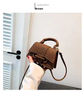Dettaglio mini borsa marrone in pelle con motivo a quadri e tracolla regolabile sottile