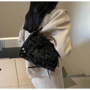 Détail du sac seau noir plissé avec cordon de serrage et ornements en métal argenté