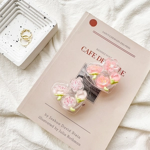 Detail of 3D heart-shaped resin phone grips with pink cherry blossoms and gold rings