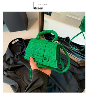 Dettaglio della mini borsa a mano verde con trama intrecciata e chiusura dorata