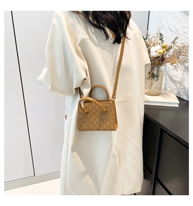 Brown monogram small square handbag styled with a long trench coat in a modern setting