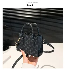 Detail of black mini crossbody bag with M-pattern texture and gold-tone metal hardware