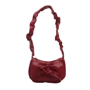 Vintage style red ruched shoulder bag with a large decorative bow and shiny PU finish