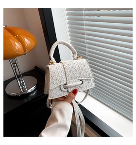 Dettaglio della mini borsa bianca con trama a incrocio e chiusura con fibbia decorativa