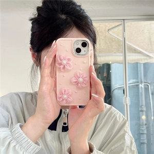 Primer plano de funda rosa para iPhone con flores 3D de tela y perlas en la mano