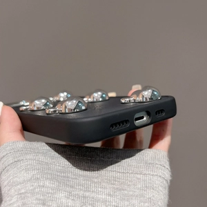 Detail of black silicone iPhone case with 3D silver hearts and precise bottom cutouts
