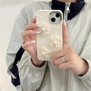 Elegante funda para iPhone con flores de tela 3D y perlas sostenida por una modelo
