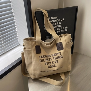 Minimalist khaki canvas tote bag for students featuring bold brown graphic lettering
