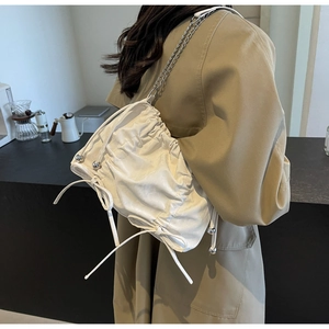 Détail du sac seau plissé blanc avec bandoulière chaîne argentée et cordon de serrage