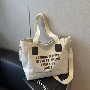 Minimalist canvas tote bag with brown artistic text and adjustable knit shoulder strap