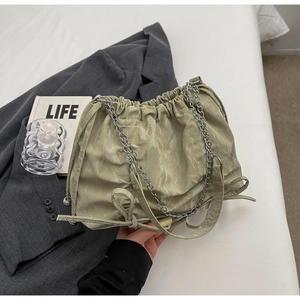 Détail du sac seau vert menthe à cordon avec texture moirée et chaîne argentée