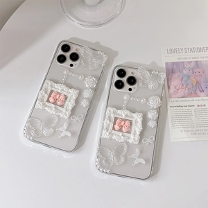 Detailed view of clear iPhone case with 3D resin roses, pearls, and butterfly charms