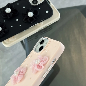 Detalle de funda para iPhone con flores de satén 3D, perlas y protección de cámara