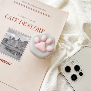 Close-up of a cute 3D pink cat paw phone socket on an aesthetic magazine background