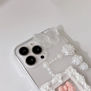 Macro detail of clear iPhone case with 3D resin roses, pearls, and bow frame decoration