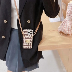 Crossbody iPhone case with checkerboard pattern and yellow 3D heart pouch charm