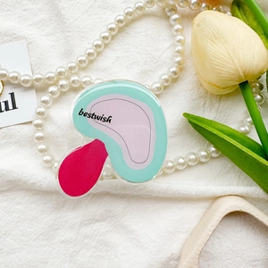 Detail of mushroom acrylic phone grip with 'bestwish' text on soft fabric background