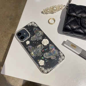 Detailed close-up of 3D pearl floral phone case with holographic butterflies and white roses