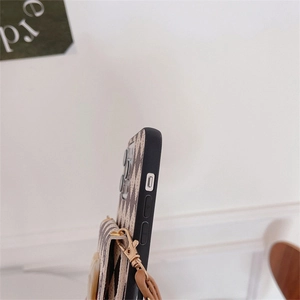Detail of the zigzag textured phone case with crossbody strap and metal lobster clasps
