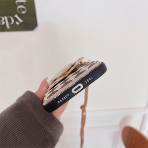 Detail view of iPhone case with check pattern, pop socket and khaki carrying strap
