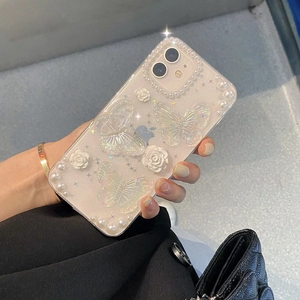 Detailed view of clear iPhone case with 3D butterflies, pearls, and white roses
