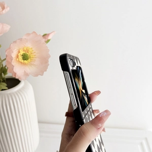 Detail of black and white checkerboard leather case for foldable phone in hand