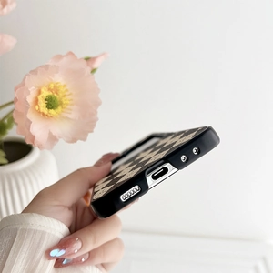 Close-up of black and white checkerboard phone case showing precise charging port cutouts