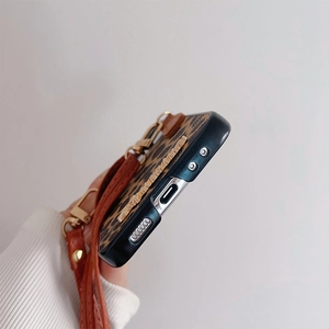 Detail of leopard print phone case featuring metal accents and a matching leather strap