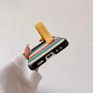 Detail of colorful striped phone case with a yellow leather wrist strap and precise ports
