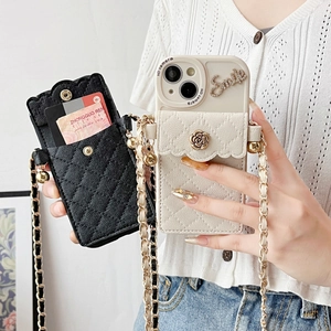 Detail of camellia flower buckle and chain strap on quilted wallet case for iPhone