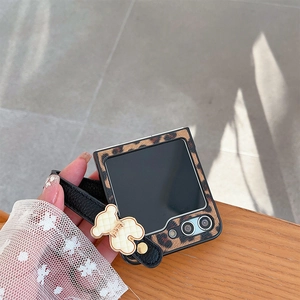 Detailed view of leopard print Samsung Z Flip phone case with leather hand strap and bear charm