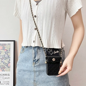 Detail of crossbody phone case with quilted card pouch, camellia flower and metal chain