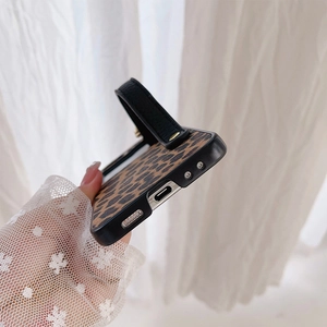 Detail of leopard print phone case with integrated black leather wrist strap and precise ports