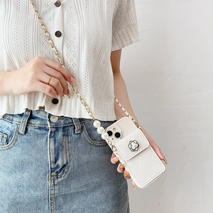Detail of white quilted phone case with camellia flower, pearl accents and crossbody chain