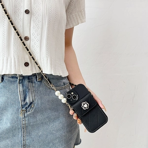 Detail of crossbody phone case with quilted leather, camellia flower and pearl strap