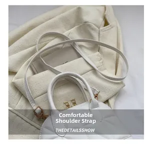 Detail showing comfortable strap and quilted texture on the white shell shoulder bag