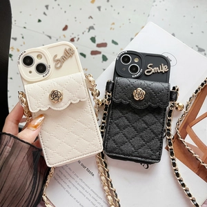 Quilted leather iPhone case detail with camellia rose charm and crossbody chain