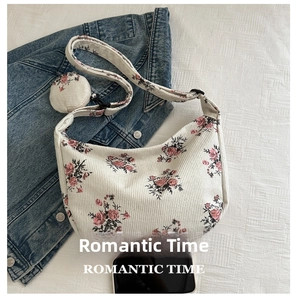 Detail of corduroy crossbody bag with rose floral patterns and small round coin purse