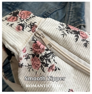 Detail of smooth metal zipper on floral corduroy bag with romantic rose patterns