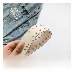 Detail of cream leather shoulder strap with three rows of silver metal studs