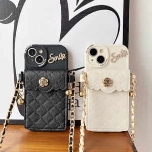Detail of crossbody iPhone case with quilted wallet, gold flower clasp, and chain strap