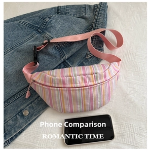 Détail du sac banane en toile rayée avec sangle réglable et boucle de fermeture