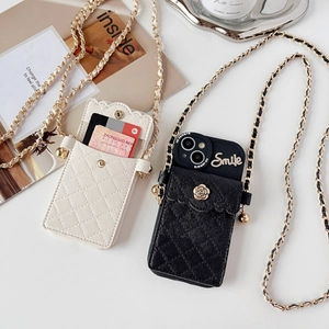 Close-up of quilted leather phone case with crossbody chain and flower charm detail