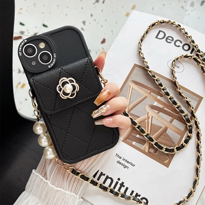 Detail of black quilted leather iPhone case with pearl camellia charm and crossbody chain