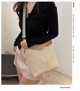 Detail of bohemian jacquard wide shoulder strap on minimalist woven straw tote bag