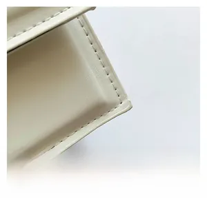Close-up of premium white leather texture and precise stitching on a chain baguette bag